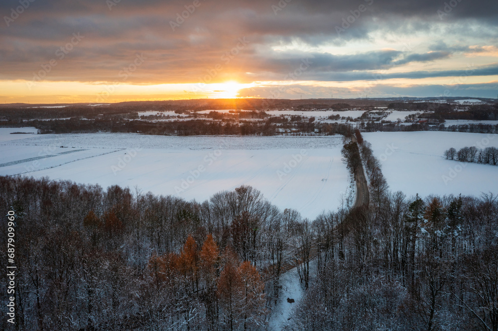 Aerial landscape of the road through snowy forest at winter, Poland.