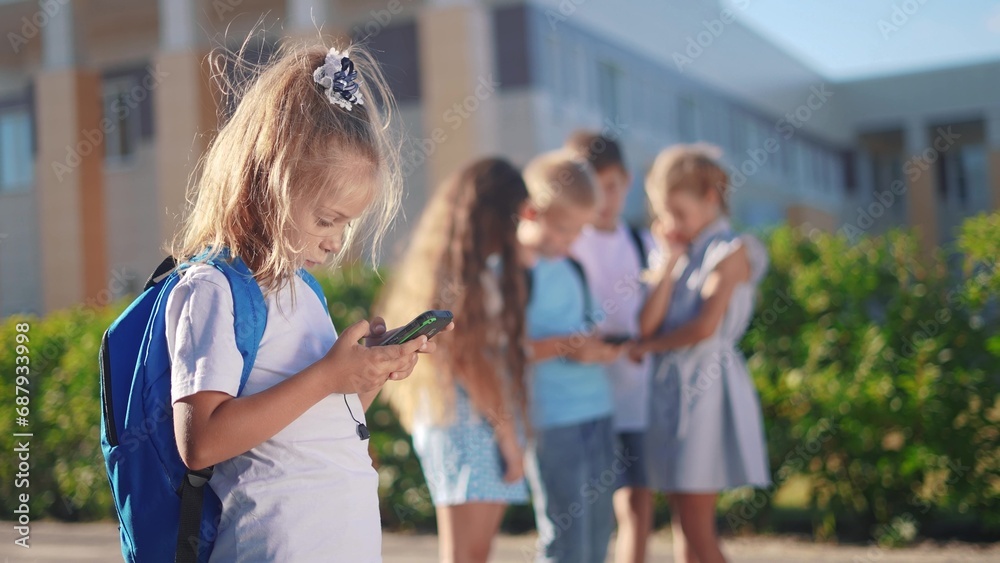 pupils stand in the schoolyard and look at phones. business concept of modern lifestyle training and development. a group of students lifestyle playing on the phone in the backyard of the school