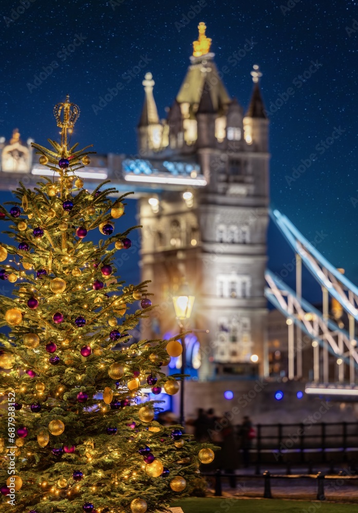 Winter night view of a festive decorated Christmas Tree in front of the iconic Tower Bridge of London, England