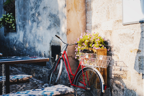 Fototapeta Naklejka Na Ścianę i Meble -  Retro bicycle with basket and flowers in a European city