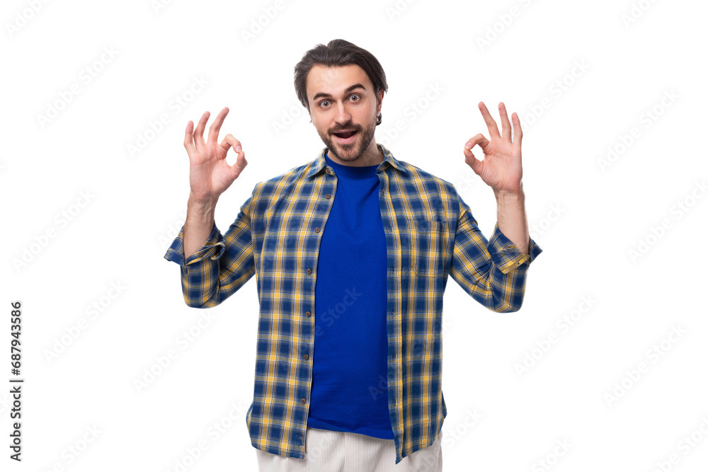 a young caucasian brunette man with a beard and an earring is dressed in a blue plaid shirt and t-shirt actively gesticulates and points with his hands a young caucasian brunette man with a beard and an earring is dressed in a blue plaid shirt and t-shirt actively gesticulates and points with his hands