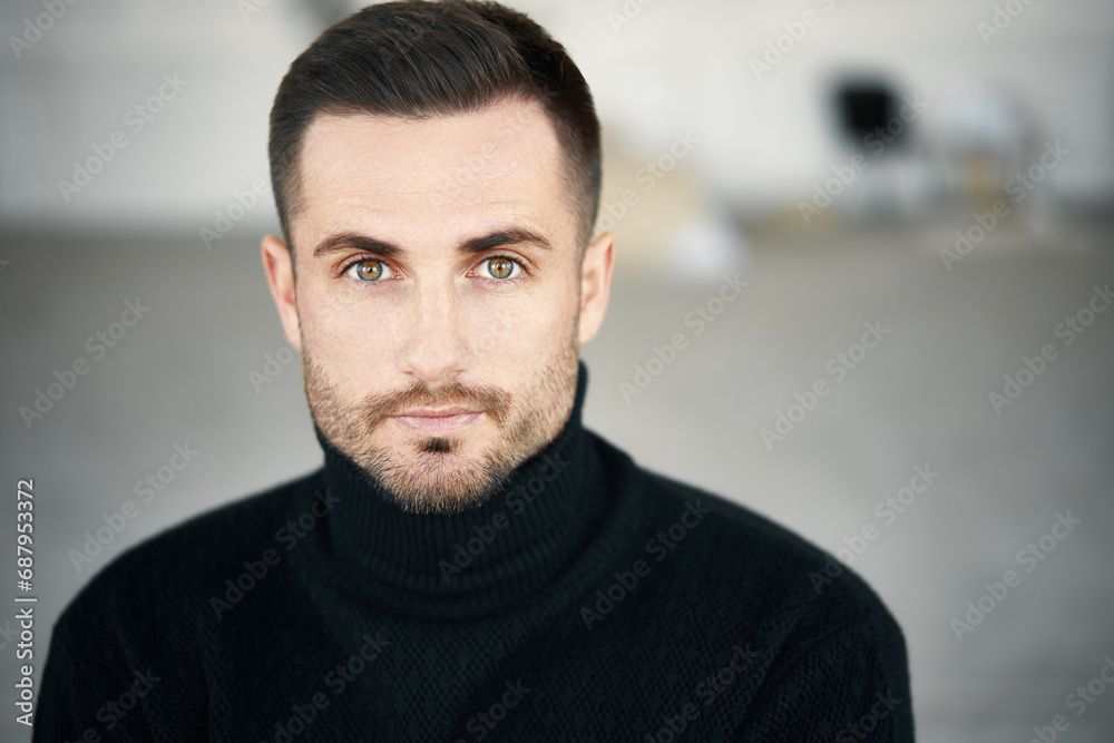 Close-up portrait of handsome young man wearing black turtleneck looking to camera over soft white background Close-up portrait of handsome young man wearing black turtleneck looking to camera over soft white background