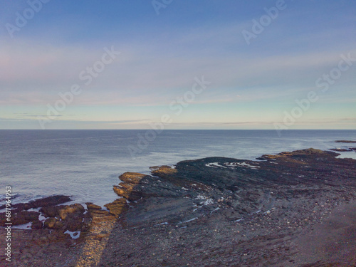 The rocky coast of the Barents Sea. Beautiful view of the rocks and the coast of the Rybachy and Sredny peninsulas, Murmansk region, Russia. The landscape is the harsh beauty of the north.