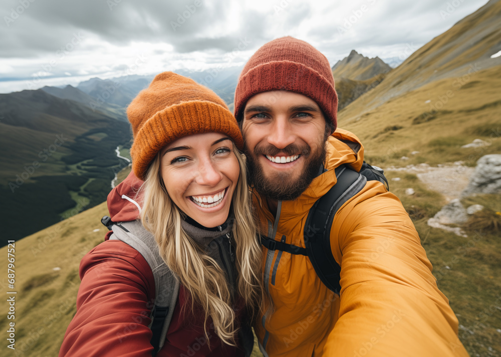 Cute couple of young people smiling and enjoying vacations trip together walking and trekking in mountains. Cheerful man and woman in love taking selfie