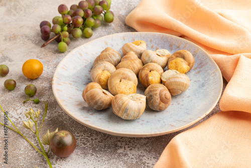 Grape (Burgundy) snails with butter and cheese on brown concrete, side view