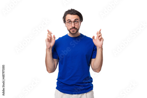 young caucasian brunette man with stylish hairstyle and beard crossed his fingers and hopes