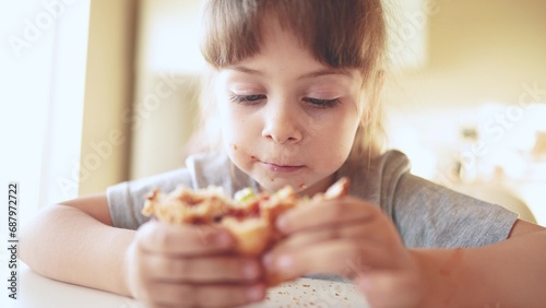 children eat burgers. fast food burger. a group of small sun children in the kitchen greedily eat fast food burgers. big family small kids having breakfast in the morning in the kitchen eating burger