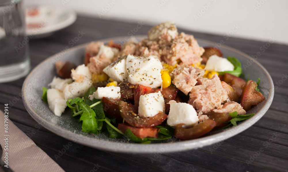 Plate of salad with tuna, corn, tomatoes and arugula Plate of salad with tuna, corn, tomatoes and arugula