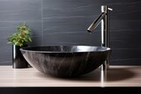 A black bowl sink sitting on top of a wooden counter. Scandinavian home interior design of modern living home.