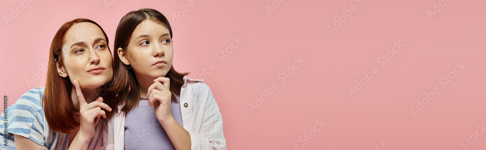 thoughtful woman with teenage girl in stylish casual clothes looking away on pink backdrop, banner thoughtful woman with teenage girl in stylish casual clothes looking away on pink backdrop, banner