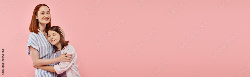 happy woman with teen daughter in stylish casual attire looking at camera on pink backdrop, banner happy woman with teen daughter in stylish casual attire looking at camera on pink backdrop, banner