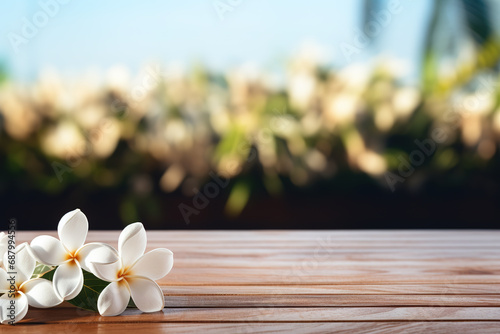 A wooden table with a white frangipani flower banner