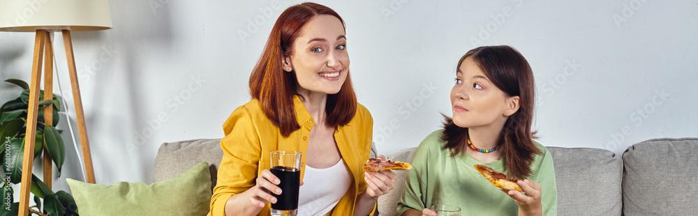 cheerful mother and teenage daughter with pizza and soda on cozy couch in living room, banner cheerful mother and teenage daughter with pizza and soda on cozy couch in living room, banner