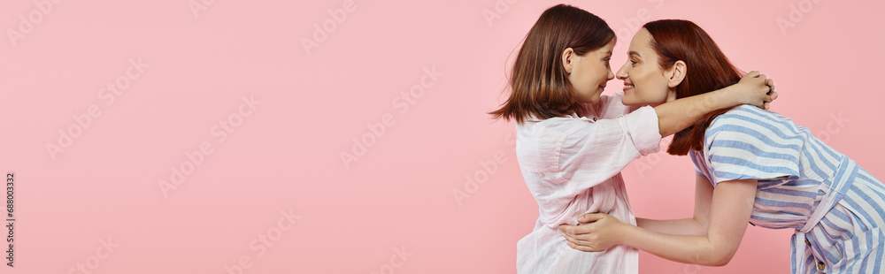 side view of joyful mom and teen daughter in stylish casual attire embracing on pink, banner side view of joyful mom and teen daughter in stylish casual attire embracing on pink, banner