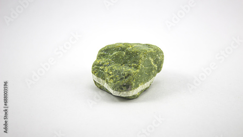 Green mineral stone with a white stripe in the middle, on a white background