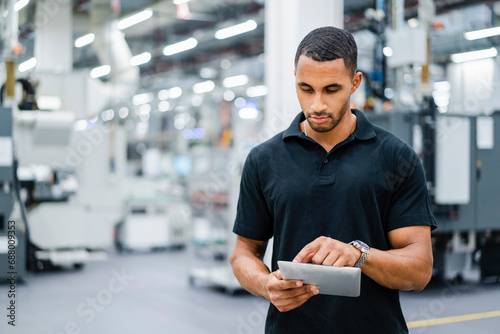 Technician using digital tablet on shop floor in a factory photo