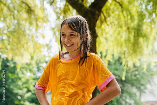 Smiling girl wearing wet clothes at park photo