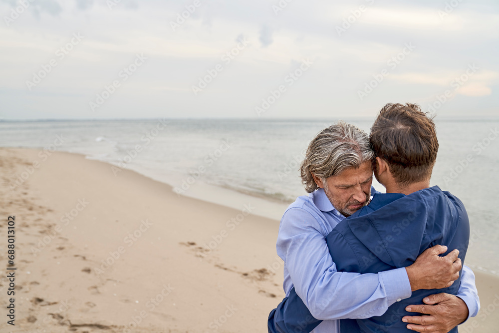 Loving father hugging son at beach Loving father hugging son at beach