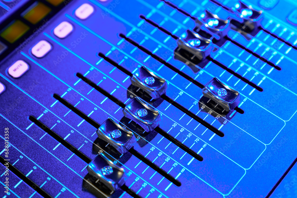 Close-up of a professional sound console in stage light. Close-up of a professional sound console in stage light.