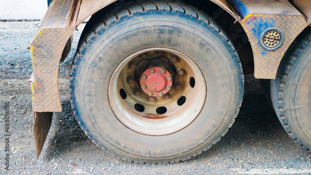 Close-up view of the dirty tires of a large truck covered with soil and dry mud.