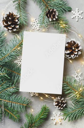 Christmas or New Year greeting card mockup with fir tree branches and cones