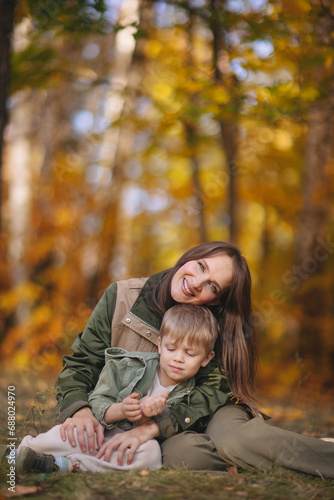 Mom and children walk in the park and enjoy the beautiful autumn nature. Happy family on an autumn walk. Natural Park. Family active holiday concept.