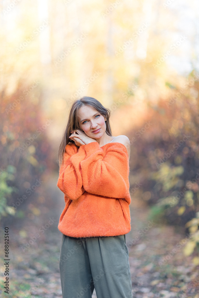 Portrait of an attractive brunette woman walking in the park at fall on a sunny day and smiling. The face of a happy beautiful woman in autumn outdoor. Portrait of an attractive brunette woman walking in the park at fall on a sunny day and smiling. The face of a happy beautiful woman in autumn outdoor.