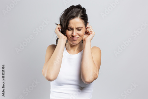 Woman closes ears with index fingers photo