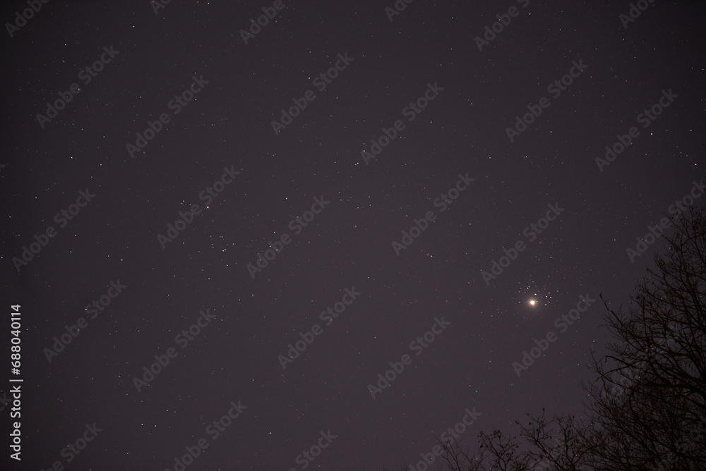 The planet Venus in the starry night sky in conjunction with the Pleiades Constellation. The group of stars The seven sisters observed from a dark place The planet Venus in the starry night sky in conjunction with the Pleiades Constellation. The group of stars The seven sisters observed from a dark place