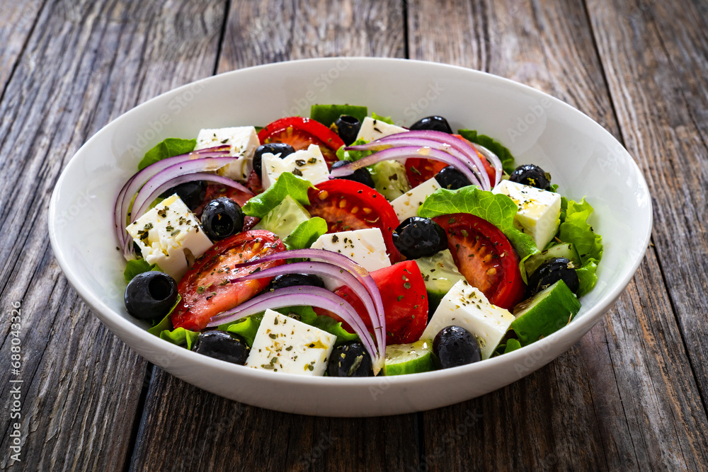 Greek style salad - fresh vegetables with feta cheese on wooden table
Greek style salad - fresh vegetables with feta cheese on wooden table