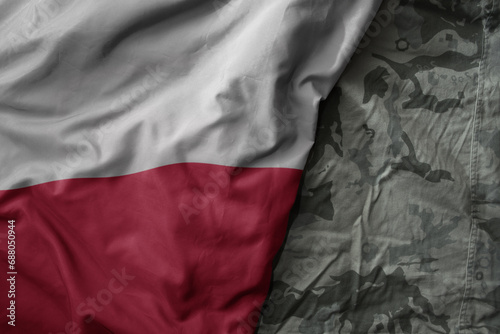 waving flag of poland on the old khaki texture background. military concept.
