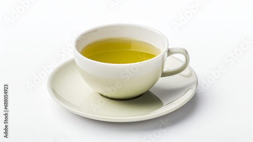 Cup of green tea with a tea bag on a saucer against a white surface