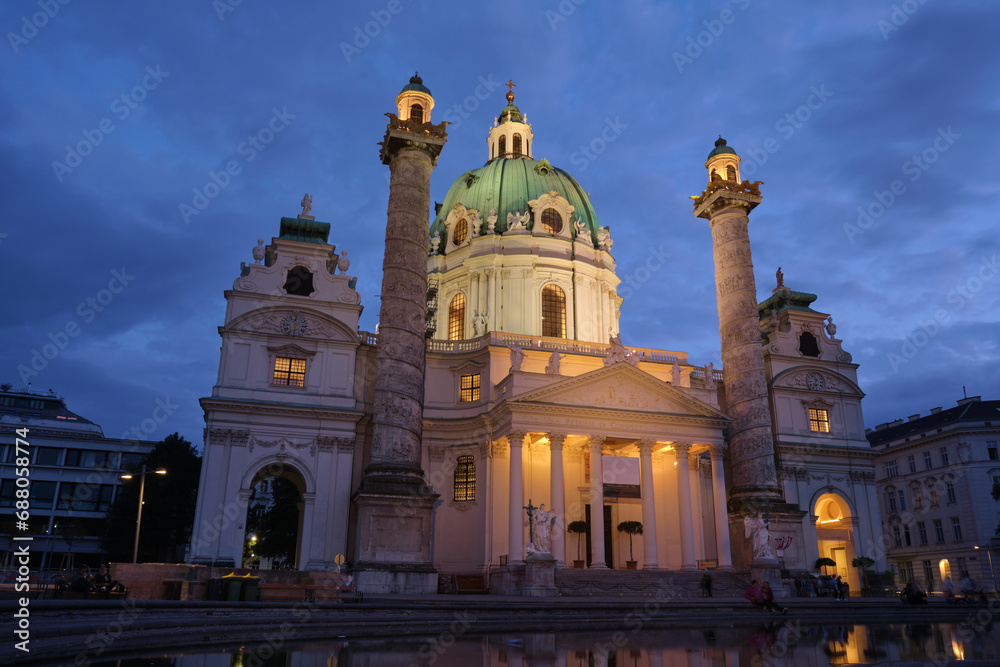 Church of Saint Charles (Karlskirche) at blue hour in Resselpark, Vienna, Austria. Illuminated landmark building.