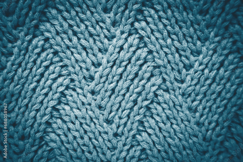 Knitted gray blue wool scarf with a diamond pattern. Abstract background. Close-up. Top view. Selective focus. Knitted gray blue wool scarf with a diamond pattern. Abstract background. Close-up. Top view. Selective focus.