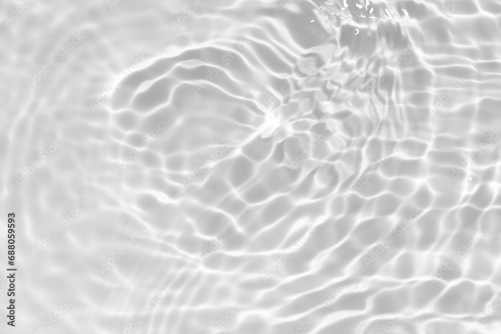 Obraz premium White water with ripples on the surface. Defocus blurred transparent white colored clear calm water surface texture with splashes and bubbles. Water waves with shining pattern texture background.