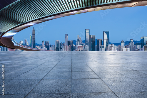 Empty square floor and bridge with city skyline at dusk in Shenzhen, Guangdong Province, China.