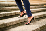 Cropped photo of businesswoman walking up stairs out side, wearing high heels