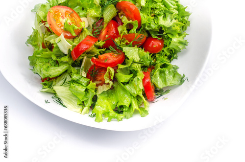 White bowl of fresh vegetables - dill, tomatoes and green salad leaves. White background, isolated.
