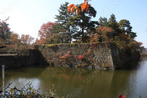 Stone wall of Tsurugajo Castle and autumn leaves in Aizuwakamatsu, Fukushima, Japan photo