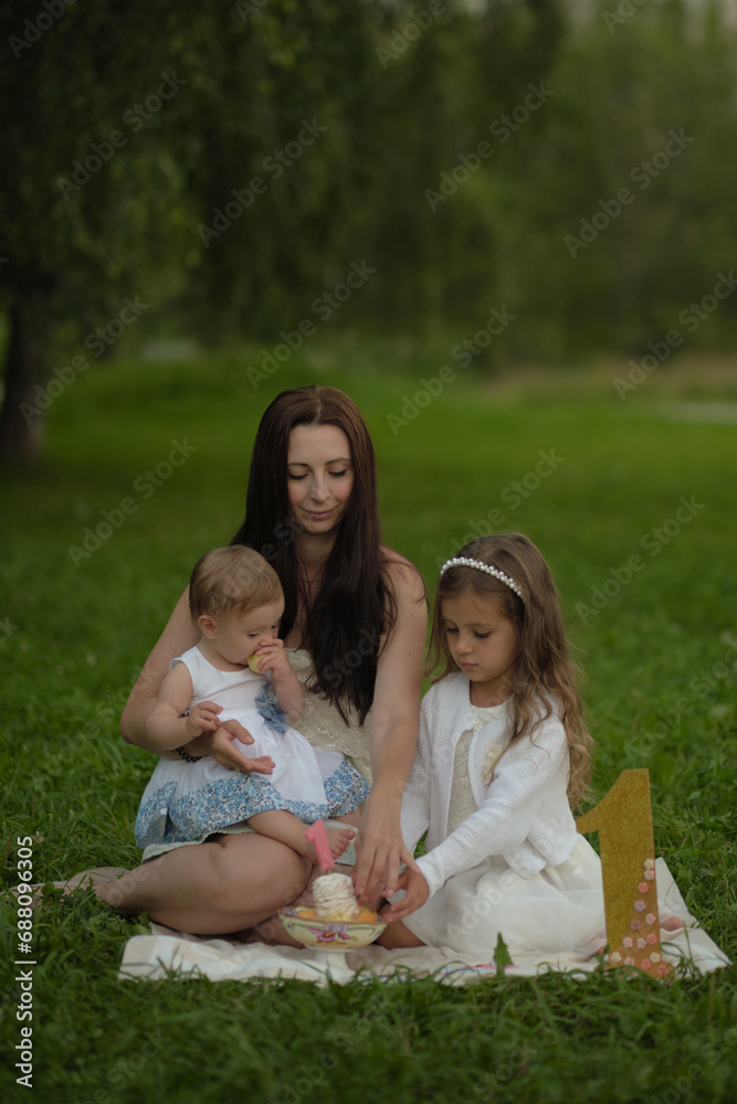 Naklejka premium The candid joy in a mother's eyes as she interacts with her children in the great outdoors, underscores the importance of family time and the instinctual bond of motherhood.