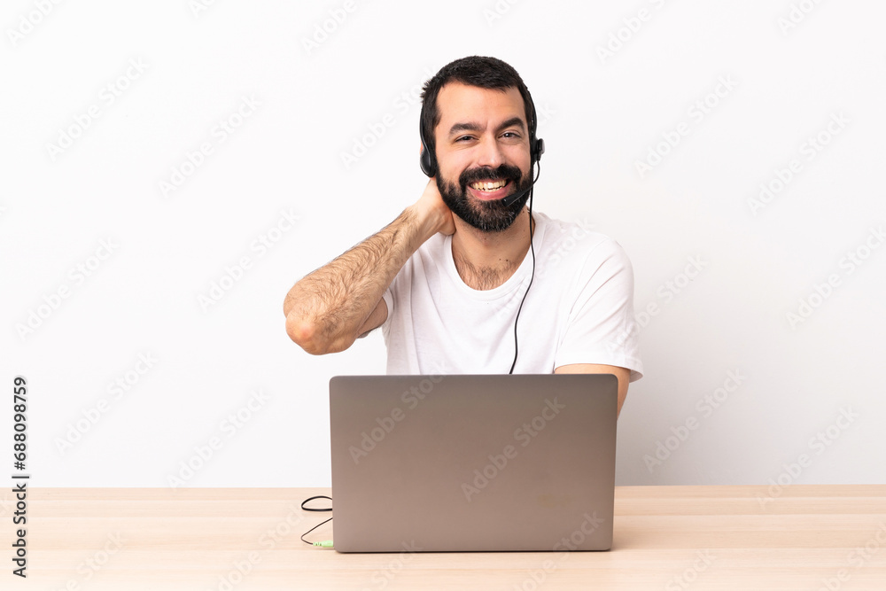 Telemarketer caucasian man working with a headset and with laptop laughing. Telemarketer caucasian man working with a headset and with laptop laughing.