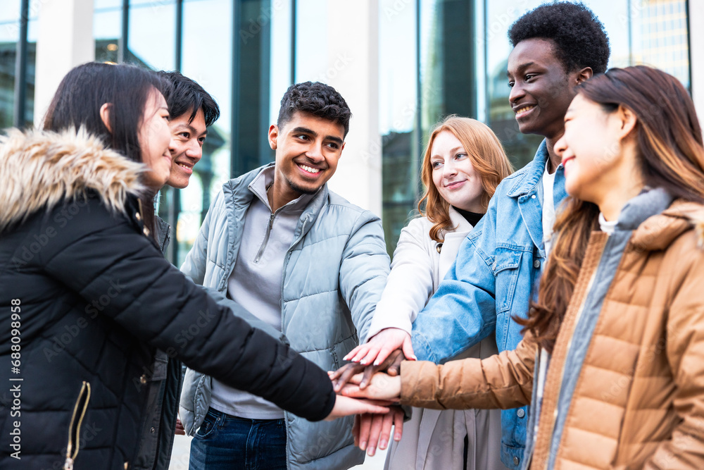 Multiracial friends putting hands on stack and enjoying teamwork Multiracial friends putting hands on stack and enjoying teamwork