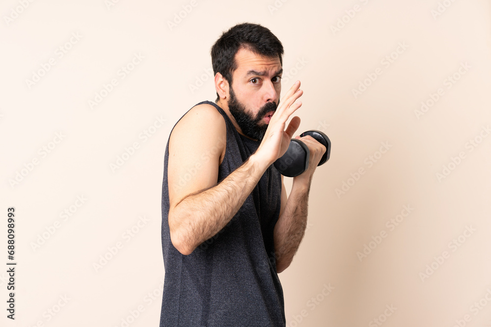 Caucasian sport man with beard making weightlifting over isolated background nervous stretching hands to the front Caucasian sport man with beard making weightlifting over isolated background nervous stretching hands to the front
