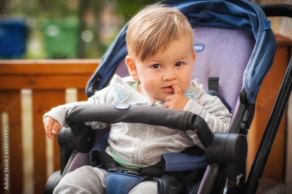 Portrait of a cute baby boy with finger in the mouth. Child, happiness and people concept Portrait of a cute baby boy with finger in the mouth. Child, happiness and people concept