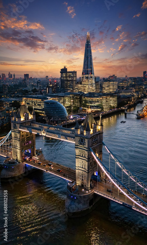 Beautiful aerial view of the illuminated Tower Bridge and skyline of London, UK, just after sunset