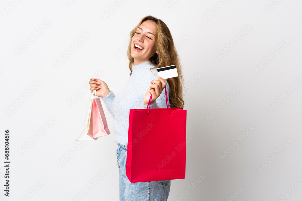 Young blonde woman isolated on white background holding shopping bags and a credit card Young blonde woman isolated on white background holding shopping bags and a credit card