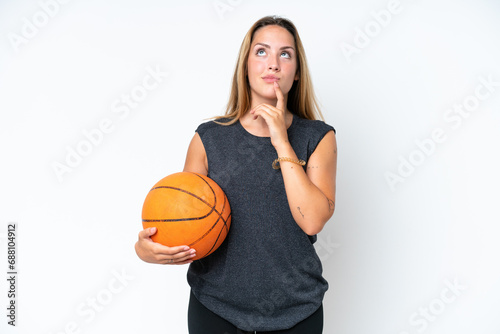 Young basketball caucasian player woman isolated on white background having doubts while looking up