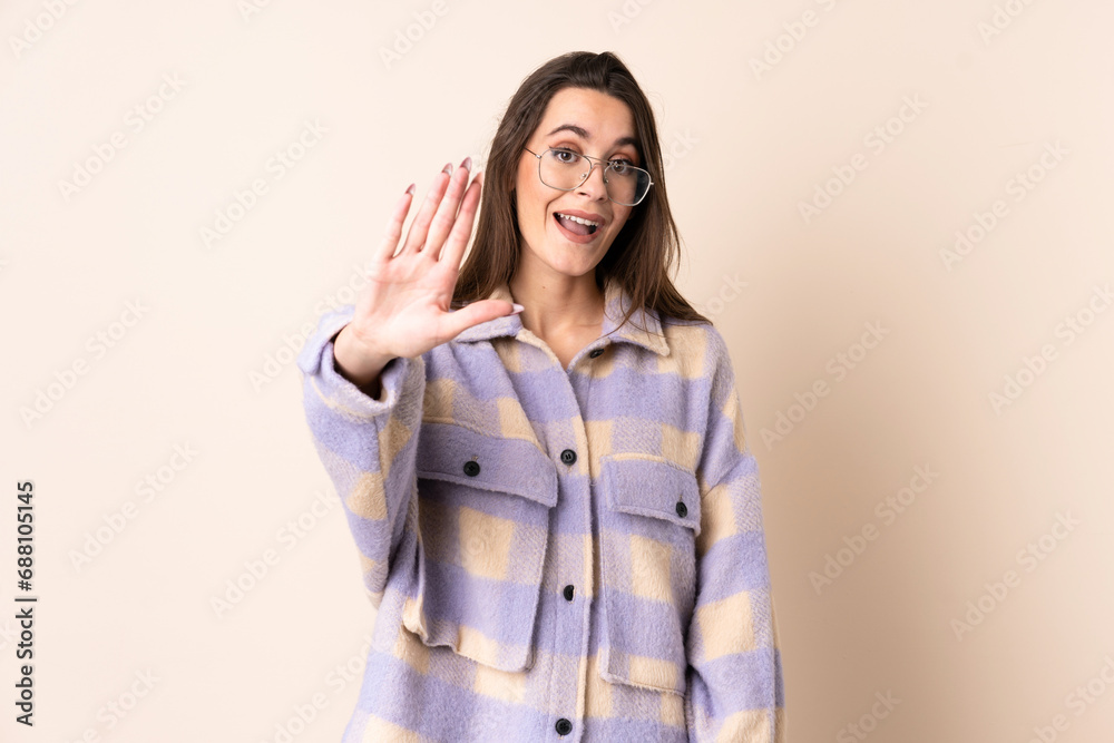 Young woman over isolated beige background counting five with fingers Young woman over isolated beige background counting five with fingers
