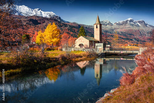 Attractive autumn view of San Lurench church in Sils im Engadin village. Marvelous morning scene of Swiss Alps. Sunny landscape of Sils lake, Switzerland, Europe. Traveling concept background. photo