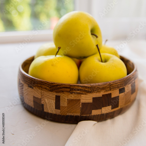 green apples on a wooden plate